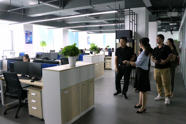 图为人事负责人刘晶带领物流学院教师参观公司办公区 摄影：林倩.jpg